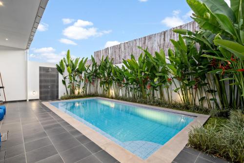 een zwembad in het midden van een tuin met planten bij Pasha Villa by Betterplace in Canggu