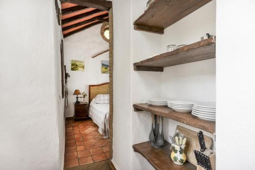 een kamer met een bed en witte borden op een plank bij Apartamento Cortijo Rural Las Aves in Jimena de la Frontera