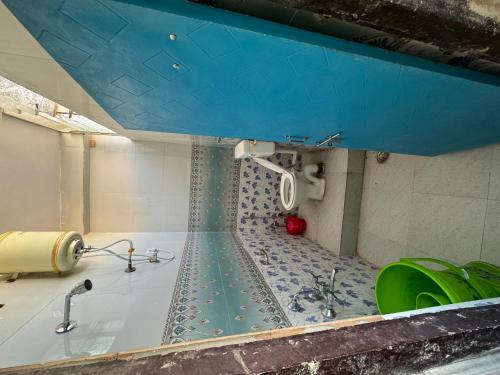 a bathroom with a tub with a blue ceiling at Daulatabad Guest House in Daulatābād