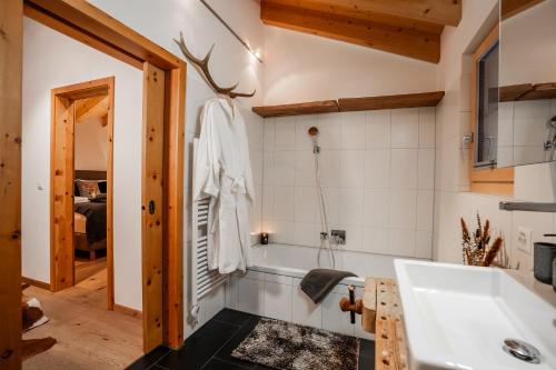 a bathroom with a tub and a sink at Ski in & out Chalet Marmo in Zermatt in Zermatt
