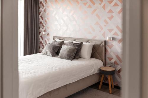 1 cama con sábanas blancas y almohadas en una habitación en Bright Kaunas apartment with Castle view en Kaunas