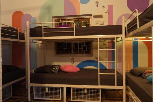 a room with bunk beds with a mural at Pappi Chulo Vagator in Vagator
