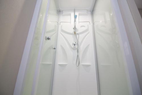a white shower stall with a white shower curtain at チーズハウス in Osaka