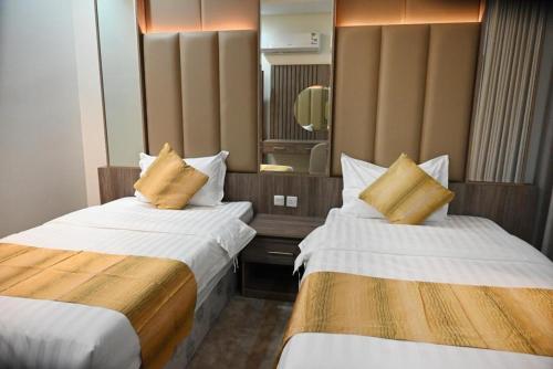 a hotel room with two beds and a mirror at فندق العابرة الرياض in Riyadh