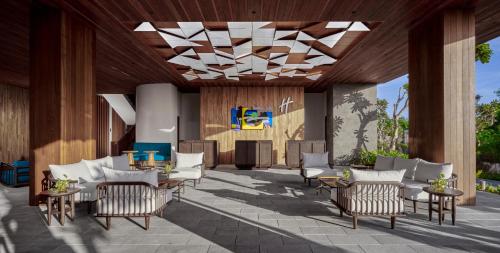 patio z krzesłami, stołami i żyrandolem w obiekcie Holiday Inn Resort Bali Canggu, an IHG Hotel w mieście Canggu