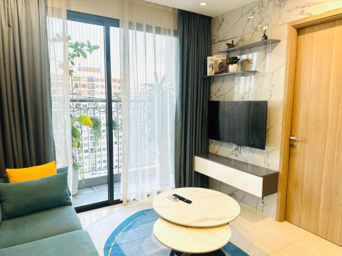 - un salon avec un canapé, une table et une télévision dans l'établissement Căn hộ chung cư cao cấp Ocean Park 2BR 2BA, à Hanoï