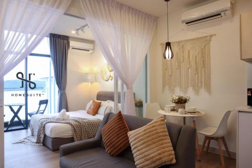 a bedroom with a bed and a couch and a table at Homesuite' Home at The Shore in Kota Kinabalu