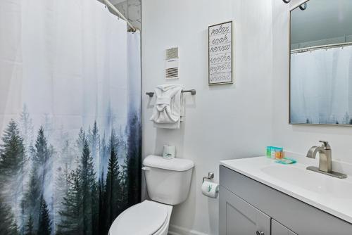 a bathroom with a toilet and a shower curtain with trees at Gatlinburg Summit Smoky Mountains View in Gatlinburg