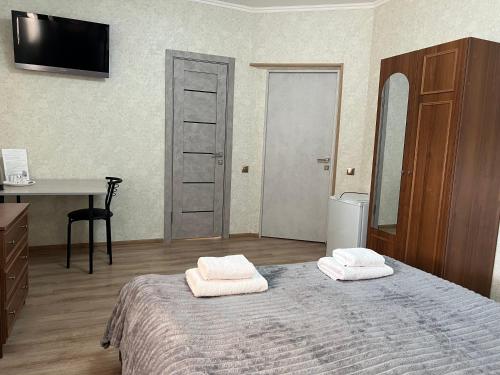 a bedroom with a bed with two towels on it at Готель «У Батька» in Truskavets