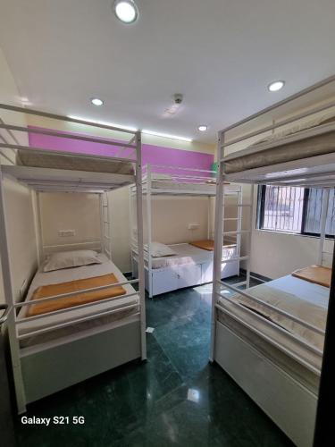 a room with three bunk beds in it at JOY HOSTEL - Digital Nomads Hostel & PG - Koregaon Park in Pune