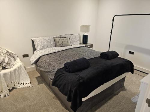 sypialnia z łóżkiem z czarnym kocem w obiekcie Luxury Spring Stays Lichfield City Centre 2 Bedroom Apartment With Free Secure Parking w mieście Lichfield