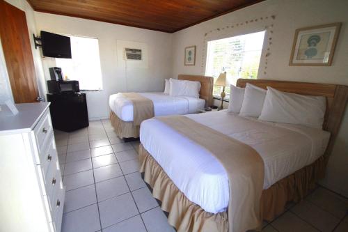 a hotel room with two beds and a television at Island Breeze Inn - Venice in Venice
