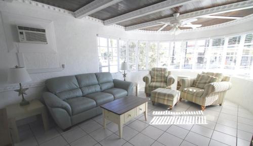 a living room with a couch and two chairs at Island Breeze Inn - Venice in Venice