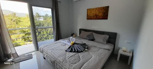 1 dormitorio con cama y ventana grande en Villa Bali Home Nittaya, en Nai Harn Beach