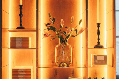a vase with flowers in it sitting on a shelf at Slottsholmen Hotell och Restaurang in Västervik