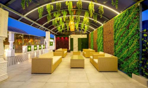 a lobby with yellow chairs and a green wall at The Embassy Inn in Noida