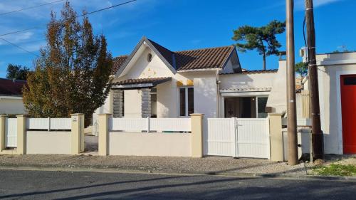 une maison blanche avec une clôture blanche dans l'établissement Saint Georges de Didonne - MAISON PROCHE PLAGE - Parc de Vallières, à Saint-Georges-de-Didonne