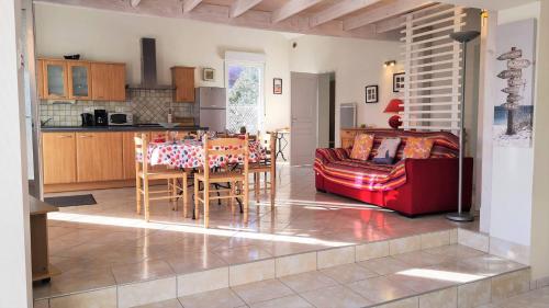 une cuisine et un salon avec une table et un canapé dans l'établissement Saint Georges de Didonne - MAISON PROCHE PLAGE - Parc de Vallières, à Saint-Georges-de-Didonne