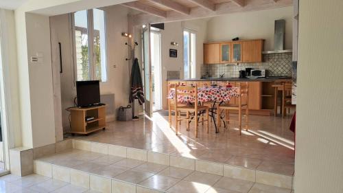 une cuisine et une salle à manger avec une table et des chaises dans l'établissement Saint Georges de Didonne - MAISON PROCHE PLAGE - Parc de Vallières, à Saint-Georges-de-Didonne
