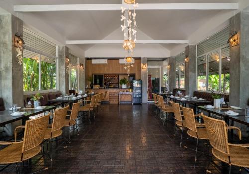 a dining room with long tables and chairs at Ploen Pirom in Lat Krabang