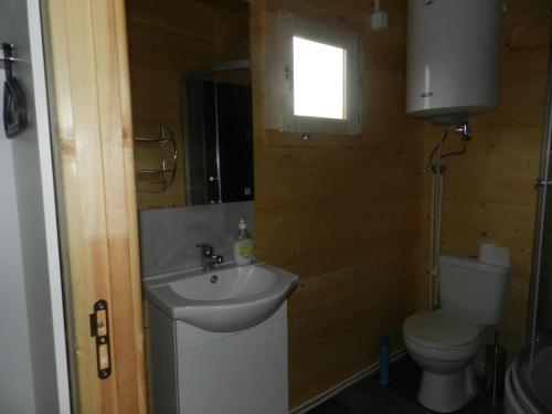 a bathroom with a sink and a toilet and a window at Domki u Szostaków in Dąbki
