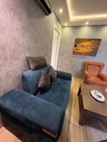 un soggiorno con divano blu e tavolo di ŞİŞLİ LÜX DAİRE AND HOME a Istanbul