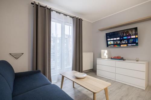 a living room with a blue couch and a table at 02 Gdynia Premium - Apartament Mieszkanie dla 2os in Gdynia