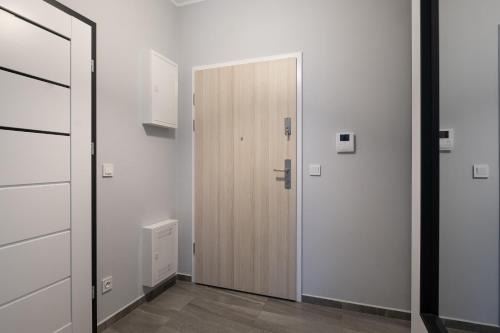 a wooden door in a room with white walls at 02 Gdynia Premium - Apartament Mieszkanie dla 2os in Gdynia