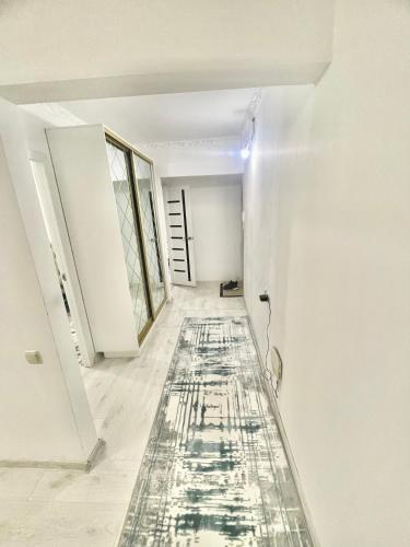 een lege kamer met een schilderij op de vloer bij Чудесный квартира in Alma-Ata