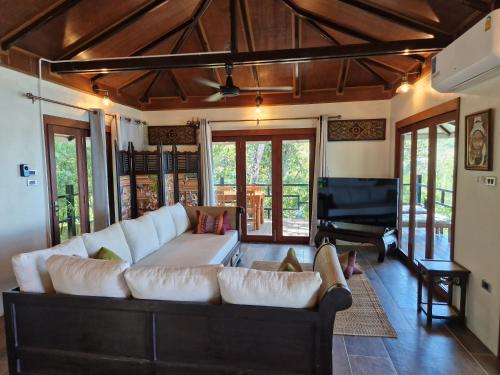 a living room with a couch and a piano at Jasmin Garden Koh Kood in Ko Kood