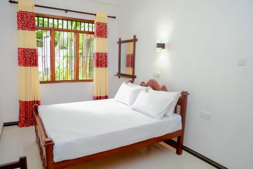 Sun See Villa Hikkaduwa في هيكادوا: سرير في غرفة مع نافذة