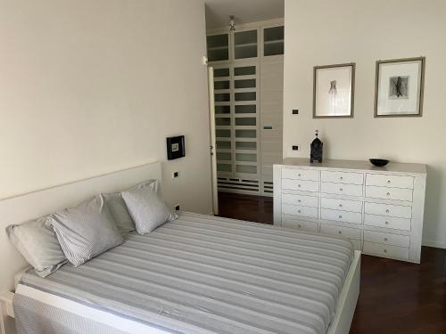 biała sypialnia z łóżkiem i komodą w obiekcie Adua Flat - perfect place for visiting Tuscany w mieście Pistoia