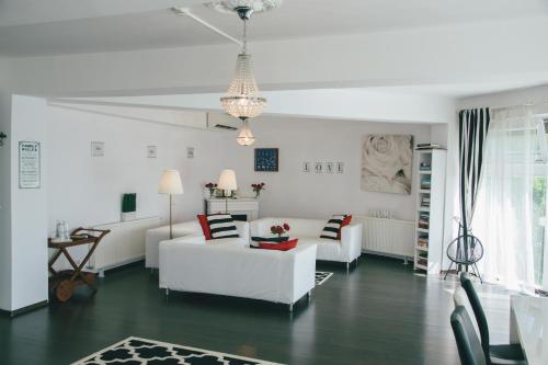 Una sala de estar con muebles blancos y una lámpara de araña. en YOUness WELLness Clinic & Retreats, en Mereni