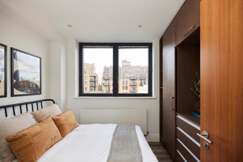 1 dormitorio con cama y ventana en The Wembley Hideaway - Bright 2BDR Flat en Londres