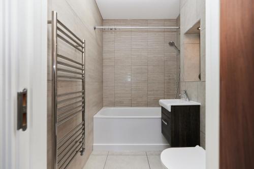 a bathroom with a tub and a toilet and a sink at The Wembley Hideaway - Bright 2BDR Flat in London