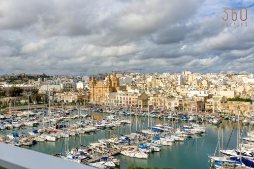 a group of boats docked in a harbor at Beautiful seafront home with private balcony & BBQ by 360 Estates in Tal-Pietà