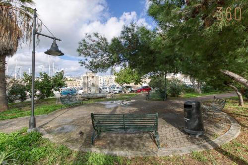 a park with a bench and a street light at Beautiful seafront home with private balcony & BBQ by 360 Estates in Tal-Pietà