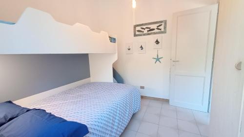 um pequeno quarto com uma cama com uma colcha azul em casa luisa em Cala Gonone
