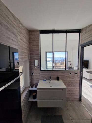 a bathroom with a sink and a large window at Sanaritz in Sanary-sur-Mer