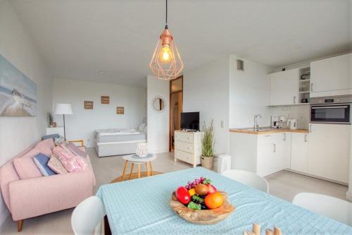 een woonkamer met een tafel met een fruitschaal erop bij Ferienpark - Haus L, App 0L0610 in Heiligenhafen