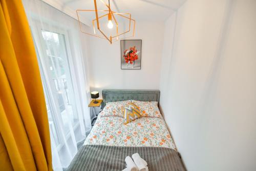 a small bedroom with a bed and a window at REZYDENCJA ZATOR in Zator
