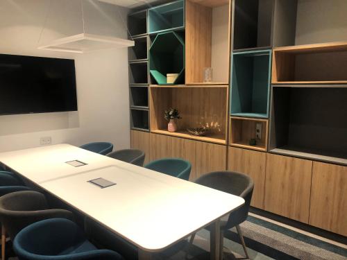 a conference room with a table and chairs and a tv at Holiday Inn Budapest-Budaörs by IHG in Budaörs
