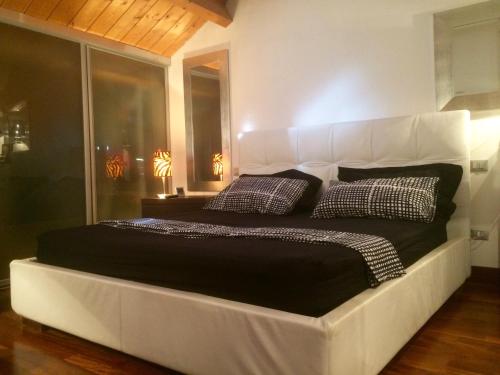 uma grande cama branca com duas almofadas num quarto em L'Incantesimo em Pescara