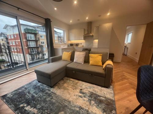 - un salon avec un canapé et une grande fenêtre dans l'établissement New build 1 bedroom modern apartment Rickmansworth, à Rickmansworth