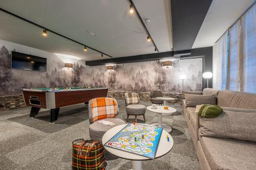 Una sala de estar con un sofá y una mesa de billar. en Hotel Cristina, en Pas de la Casa