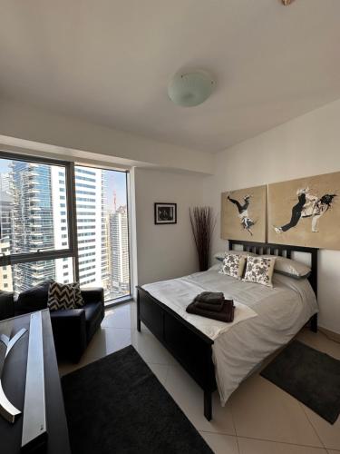 a bedroom with a bed and a large window at Amazing Double Room with En-suite, Marina and Sea views with shared kitchen in Dubai