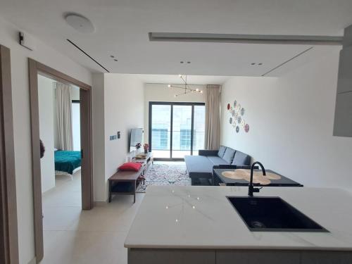 a kitchen and living room with a couch and a sink at 1BR Canal View 10 min to Dubai Mall & Burj in Dubai