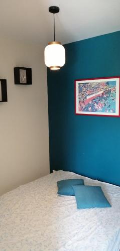 une chambre avec un lit avec un mur bleu dans l'établissement gite neuf, à Laluque