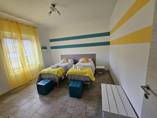 2 Betten in einem Zimmer mit gelben und blauen Streifen in der Unterkunft sorrento sleepandgo in Sorrent
