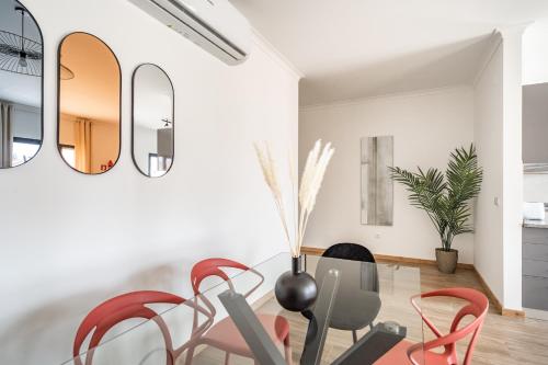 a living room with red chairs and mirrors at Akisol Portalegre Charm in Ponte de Sor